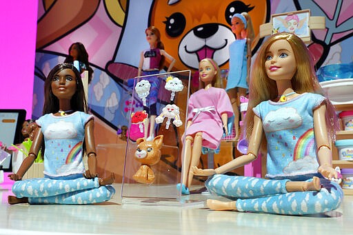 Breathe with Me Barbie, left and right, and Barbie Face Mask Spa Day, seated center, are displayed at Toy Fair New York, in the Javits Convention Center, Monday, Feb. 24, 2020.  From Baby Yoda to eco-friendly stacking rings, toymakers displayed an array of goods that they hope will be on kids' wish lists for the holiday 2020 season. The four-day Toy Fair comes as the U.S. toy industry has been whipsawed by a number of obstacles.  (AP Photo/Richard Drew)