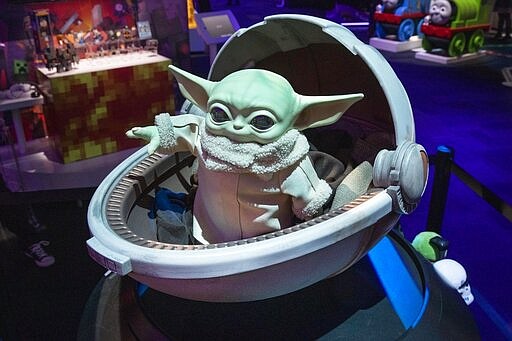 A Baby Yoda doll, by Mattel, is displayed at Toy Fair New York, in the Javits Convention Center, Monday, Feb. 24, 2020. From Baby Yoda to eco-friendly stacking rings, toymakers displayed an array of goods that they hope will be on kids' wish lists for the holiday 2020 season. The four-day Toy Fair comes as the U.S. toy industry has been whipsawed by a number of obstacles.  (AP Photo/Richard Drew)