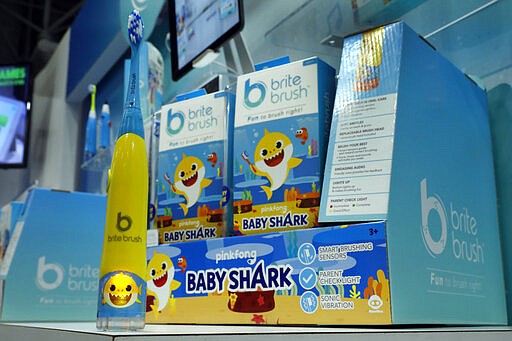 The BriteBrush Pinkfong Baby Shark toothbrush, from WOWEE, is displayed at Toy Fair New York, in the Javits Convention Center, Monday, Feb. 24, 2020.  From Baby Yoda to eco-friendly stacking rings, toymakers displayed an array of goods that they hope will be on kids' wish lists for the holiday 2020 season. The four-day Toy Fair comes as the U.S. toy industry has been whipsawed by a number of obstacles.  (AP Photo/Richard Drew)