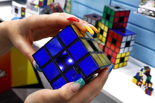 A new Rubik's Cube, by Super Impulse, is demonstrated at Toy Fair New York, in the Javits Convention Center, Monday, Feb. 24, 2020.  From Baby Yoda to eco-friendly stacking rings, toymakers displayed an array of goods that they hope will be on kids' wish lists for the holiday 2020 season. The four-day Toy Fair comes as the U.S. toy industry has been whipsawed by a number of obstacles.  (AP Photo/Richard Drew)