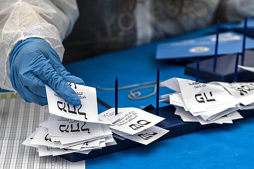 Electoral officials count ballots cast by Israelis under home quarantine after returning from Coronavirus infected zones in the city of Shoham, Israel, Wednesday, March 4, 2020. (AP Photo/Tsafrir Abayov)