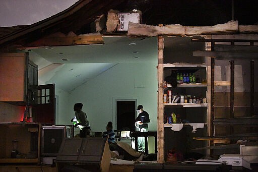 In this Tuesday, March 3, 2020 photo, residents of a home at Underwood St. and 16th Ave. N. try to figure out their next steps after a tornado ripped a wall off their home in the Elizabeth Park neighborhood of Nashville, Tenn. (George Walker IV/The Tennessean via AP)