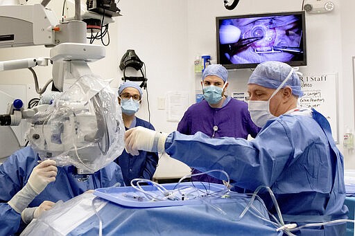 In this undated photo provided by the Oregon Health &amp; Science University on Wednesday, March 4, 2020, Dr. Mark Pennesi, who leads OHSU's involvement in the trial, center right, looks on as staff at school's Casey Eye Institute perform the first-ever in vivo CRISPR gene edit procedure for the BRILLIANCE clinical trial in Portland, on a patient who had an inherited form of blindness. It may take up to a month to see if it worked to restore vision. (Kristyna Wentz-Graff/OHSU via AP)