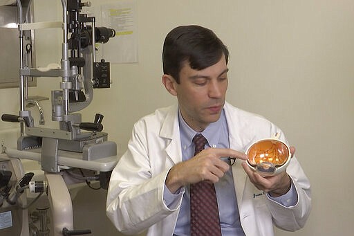 Dr. Jason Comander, inherited retinal disorder specialist at Massachusetts Eye and Ear Infirmary in Boston points to a model of an eye during an interview on Jan. 8, 2020. Comander's hospital plans to enroll patients in a gene editing treatment for blindness study. He said it marks &#147;a new era in medicine&#148; using a technology that &#147;makes editing DNA much easier and much more effective.&#148; (AP Photo/Rodrique Ngowi)