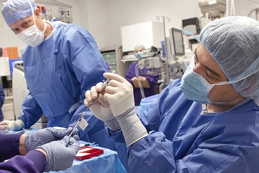 In this undated photo provided by the Oregon Health &amp; Science University on Wednesday, March 4, 2020, Dr. Andreas Lauer, right, prepares to perform the first-ever in vivo CRISPR gene edit procedure for the BRILLIANCE clinical trial at the school's Casey Eye Institute in Portland, on a patient who had an inherited form of blindness. It may take up to a month to see if it worked to restore vision. (Kristyna Wentz-Graff/OHSU via AP)