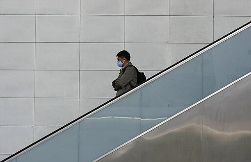 A man wearing a face mask rides the escalator in Seoul, South Korea, Wednesday, March 4, 2020. (AP Photo/Lee Jin-man)