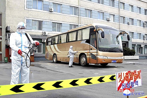 In this undated photo provided released on Wednesday, March 4, 2020, by the North Korean government, workers wearing protective suits spray disinfectant on a bus as a precaution against the new coronavirus at a parking lot in Sinuiju, North Korea. Independent journalists were not given access to cover the event depicted in this image distributed by the North Korean government. The content of this image is as provided and cannot be independently verified. Korean language watermark on image as provided by source reads: &quot;KCNA&quot; which is the abbreviation for Korean Central News Agency. (Korean Central News Agency/Korea News Service via AP)