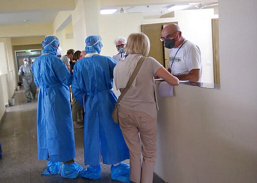 This Tuesday, March 3, 2020 photograph provided by India&#146;s Indo Tibetan Border Police Force (ITBP) shows Italian nationals being quarantined to guard against new coronavirus fill up forms at ITBP's quarantine facility in Chhawla near New Delhi, India. (Indo Tibetan Border Police Force via AP)