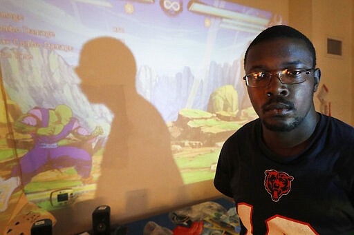 In this Thursday, Feb. 27, 2020, photo, Richard Butler poses for a portrait during a break playing a video game in an apartment that a friend is letting him and his fiance live in on Chicago's Southside. Having food stamps offers Butler a stability he's rarely known in his 25 years. But that stability is being threatened for people like him, who are able-bodied, without dependents and between the ages 18 and 49. (AP Photo/Charles Rex Arbogast)