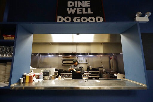 In this Jan. 29, 2020, photo, chef Samara Henderson checks a lunch order paper at Inspiration Kitchens in Chicago. From Hawaii to Pennsylvania, states are scrambling to blunt the impact, with roughly 700,000 people at risk of losing benefits unless they meet certain work, training or school requirements. Inspiration Corporation, a nonprofit, runs the training kitchen and restaurant out of a converted Chicago warehouse. (AP Photo/Nam Y. Huh)