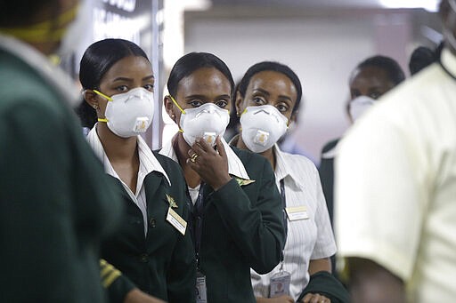 Ethiopian Airline cabin crew wait to be screened by Nigerian port health officials for COVID-19 virus, upon arrival at the Murtala Muhammed International Airport in Lagos, Nigeria, Wednesday, March 4, 2020. (AP Photo/ Sunday Alamba)