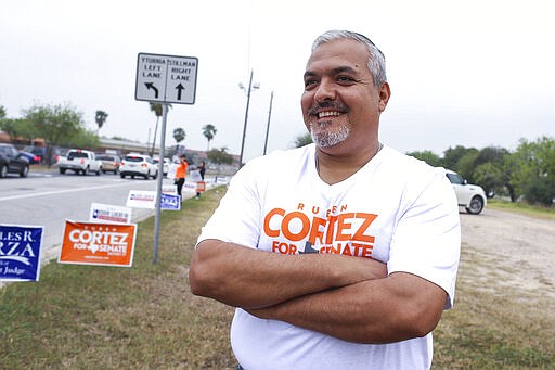 Ruben Cortez stands along the road with his supporters during his campaign for Senate District 27 Tuesday, March 3, 2020, outside the polling location at Yturria Elementary School in Brownsville, Texas. (Denise Cathey/The Brownsville Herald via AP)