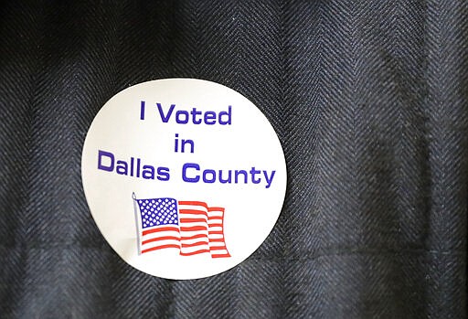 Democrat Jamie Wilson displays a sticker after voting in the Super Tuesday primary at John H. Reagan Elementary School in the Oak Cliff section of Dallas, Tuesday, March 3, 2020. (AP Photo/LM Otero)