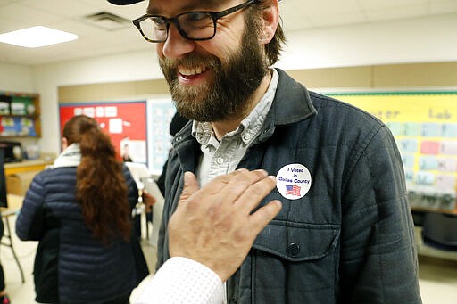 Democrat Jamie Wilson gets a sticker after voting in the Super Tuesday primary at John H. Reagan Elementary School in the Oak Cliff section of Dallas, Tuesday, March 3, 2020. (AP Photo/LM Otero)