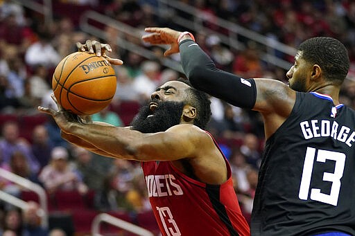 Houston Rockets' James Harden, left, is fouled by Los Angeles Clippers' Paul George during the second half of an NBA basketball game Thursday, March 5, 2020, in Houston. The Clippers won 120-105. (AP Photo/David J. Phillip)