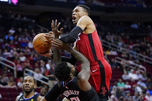 Houston Rockets' Russell Westbrook, right, is fouled by Los Angeles Clippers' Patrick Beverley, bottom, during the second half of an NBA basketball game Thursday, March 5, 2020, in Houston. The Clippers won 120-105. (AP Photo/David J. Phillip)