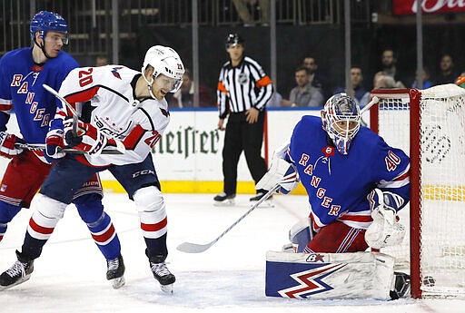 New York Rangers right wing Kaapo Kakko, left, and Washington Capitals center Lars Eller (20) look behind Rangers goaltender Alexandar Georgiev (40) as the puck goes in for a goal by Capitals left wing Carl Hagelin during the first period of an NHL hockey game Thursday, March 5, 2020, in New York. (AP Photo/Kathy Willens)