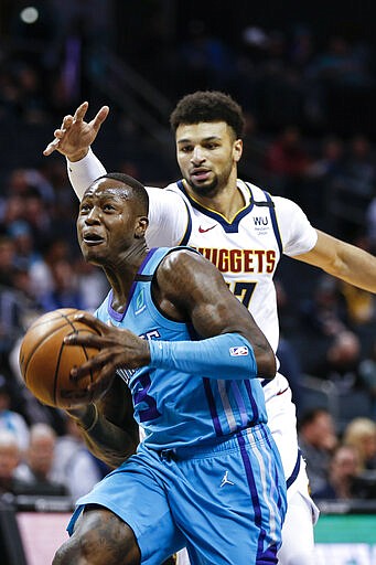 Charlotte Hornets guard Terry Rozier, left, drives to the basket ahead of Denver Nuggets guard Jamal Murray during the first half of an NBA basketball game in Charlotte, N.C., Thursday, March 5, 2020. (AP Photo/Nell Redmond)