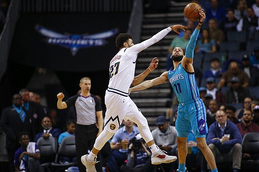 Charlotte Hornets forward Cody Martin, right, breaks up a pass by Denver Nuggets guard Jamal Murray during the first half of an NBA basketball game in Charlotte, N.C., Thursday, March 5, 2020. (AP Photo/Nell Redmond)