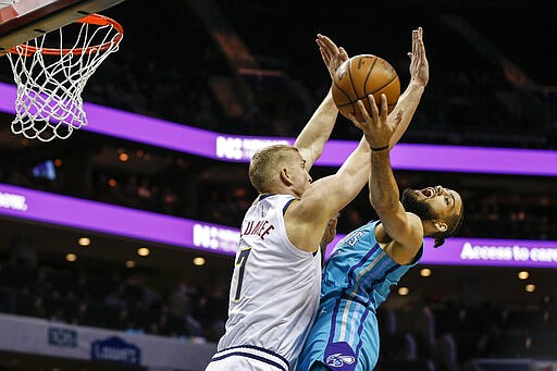 Denver Nuggets forward Mason Plumlee, left, fouls Charlotte Hornets forward Caleb Martin during the first half of an NBA basketball game in Charlotte, N.C., Thursday, March 5, 2020. (AP Photo/Nell Redmond)