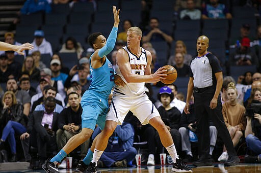 Denver Nuggets forward Mason Plumlee, right, looks to pass against Charlotte Hornets forward P.J. Washington during the first half of an NBA basketball game in Charlotte, N.C., Thursday, March 5, 2020. (AP Photo/Nell Redmond)