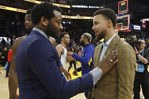 Injured Washington Wizards guard John Wall, left, talks with injured Golden State Warriors guard Stephen Curry after the Wizards beat the Warriors in an NBA basketball game in San Francisco, Sunday, March 1, 2020. (AP Photo/Jeff Chiu)