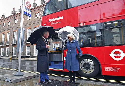 Britain's Prince Charles, and Camilla, the Duchess of Cornwall react before boarding a new electric double decker bus to leave Clarence House in London to go the London Transport Museum to take part in celebrations to mark 20 years of Transport for London, Wednesday, March 4, 2020. (Stefan Rousseau/PA via AP)