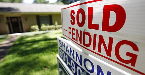 FILE - This June 13, 2019, photo shows a house with a &quot;sold pending&quot; sign fixed on the realtor's sign in northeast Jackson, Miss.  Many Americans may be unnecessarily talking themselves out of homeownership. Thirty-seven percent of non-homeowners say not having enough saved for a down payment is holding them back from homeownership, but 62% of Americans incorrectly believe you have to have at least 20% of a home&#146;s purchase price to buy, according to NerdWallet&#146;s 2020 Home Buyer Report.  (AP Photo/Rogelio V. Solis, File)