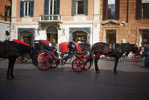 A Botticella (traditional Roman horse-driven touristic carriage) driver waits for customers in Piazza di Spagna, at the bottom of the Spanish Steps, in Rome, Thursday, March 5, 2020.  Italy's virus outbreak has been concentrated in the northern region of Lombardy, but fears over how the virus is spreading inside and outside the country has prompted the government to close all schools and Universities nationwide for two weeks. (AP Photo/Andrew Medichini)