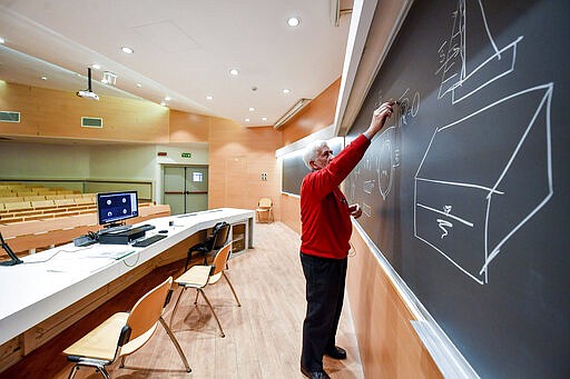 A teacher gives on-line lessons via webcam at the Politecnico University in Milan, Italy, Thursday, March 5, 2020. Italy's virus outbreak has been concentrated in the northern region of Lombardy, but fears over how the virus is spreading inside and outside the country has prompted the government to close all schools and Universities nationwide for two weeks. (Claudio Furlan/LaPresse via AP)