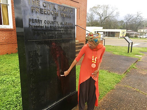 In this Feb. 18, 2020, photo, Della Simpson?Maynor?finds her name and her siblings names on a monument erected for people who marched and fought for voting rights in Marion, Ala. Maynor?remembers the?mounted?police officer cracking her elbow with a baton. She recalls the panicked marchers?unable to escape the onslaught, and the scuffle between officers and a young church deacon who was trying to ?protect his mother and grandfather.?(AP Photo/Gary Fields)