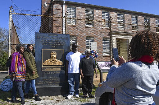 In this Feb. 29, 2020, photo, the family of the Rev. James Orange, a project coordinator for the Southern Christian Leadership Conference, pose for a photo outside the Perry County jail in Marion, Ala. Orange was housed in the jail in 1965 after his arrest while organizing a voter registration drive. Family members from left, daughters Jamida and Deirdre Orange, son Cleon Orange and wife Cleophas Orange. (AP Photo/Julie Bennett)