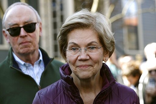 Sen. Elizabeth Warren, D-Mass., speaks outside her home beside her husband Bruce Mann, Thursday, March 5, 2020, in Cambridge, Mass., after she dropped out of the Democratic presidential race. (AP Photo/Steven Senne)