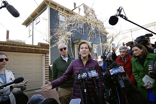 Sen. Elizabeth Warren, D-Mass., with her husband Bruce Mann beside her, speaks to the media outside her home, Thursday, March 5, 2020, in Cambridge, Mass., after she dropped out of the Democratic presidential race. (AP Photo/Steven Senne)