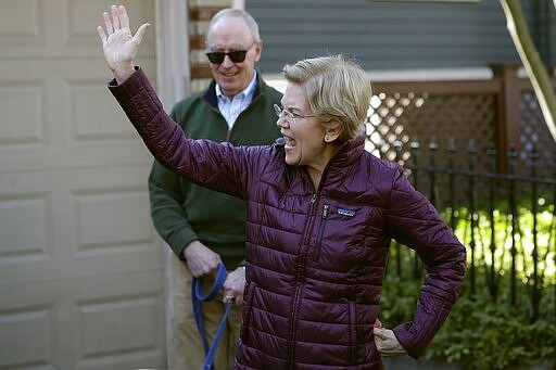 Sen. Elizabeth Warren, D-Mass., with her husband Bruce Mann, acknowledge supporters outside her home, Thursday, March 5, 2020, in Cambridge, Mass., as she arrives to speak to the media after she dropped out of the Democratic presidential race. (AP Photo/Steven Senne)