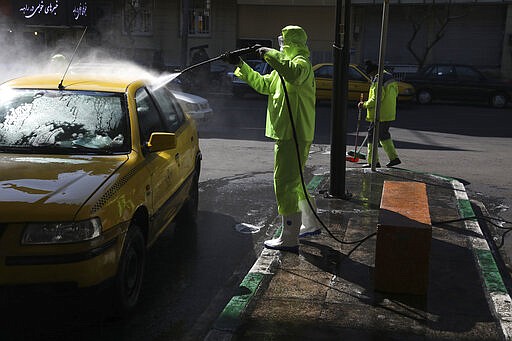 A city worker disinfects a taxi because of the new coronavirus in Tehran, Iran, Thursday, March 5, 2020. Iran has one of the highest death tolls in the world from the new coronavirus outside of China, the epicenter of the outbreak. (AP Photo/Vahid Salemi)