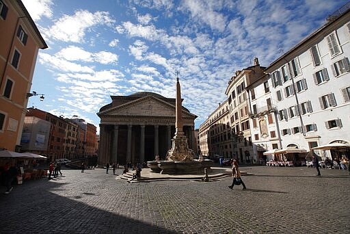 People stroll along Pantheon square in Rome, Thursday, March 5, 2020. Italy closed all schools and universities and barred fans from all sporting events for the next few weeks, as governments trying to curb the spread of the coronavirus around the world resorted to increasingly sweeping measures that transformed the way people work, shop, pray and amuse themselves. (AP Photo/Andrew Medichini)