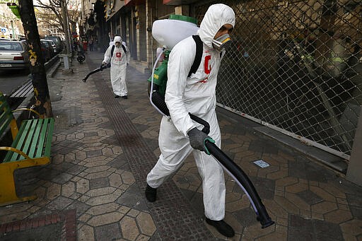 Firefighters disinfect a sidewalk to help prevent the spread of the new coronavirus in Tehran, Iran, Thursday, March 5, 2020. Iran has one of the highest death tolls in the world from the new coronavirus outside of China, the epicenter of the outbreak. (AP Photo/Vahid Salemi)