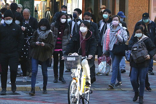 People wearing face masks as a precaution against the new coronavirus walk on a street in Taipei, Taiwan, Thursday, March 5, 2020. (AP Photo/Chiang Ying-ying)