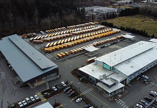 School buses are parked at the Northshore School District Transportation Center, Thursday morning, March 5, 2020, in Bothell, Wash., after the district closed all schools over coronavirus concerns. NSD superintendent Michelle Reid said all of the 26 schools in the district will be shuttered while officials monitor the situation and listen to the health department for more recommendations.  (Ken Lambert/The Seattle Times via AP)