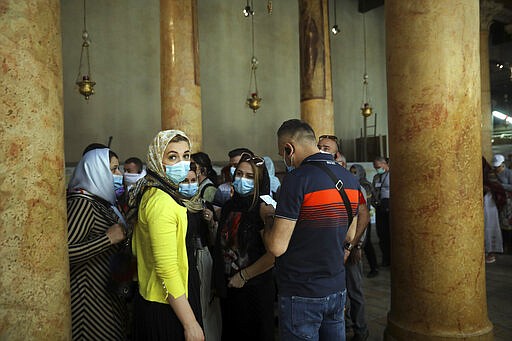 People visit the Church of the Nativity in Bethlehem, West Bank, Thursday, March 5, 2020. Palestinian authorities said the Church of the Nativity in Bethlehem, built atop the spot where Christians believe Jesus was born, will close indefinitely due to coronavirus concerns. (AP Photo/Mahmoud Illean)