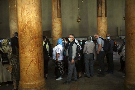 People visit the Church of the Nativity in Bethlehem, West Bank, Thursday, March 5, 2020. Palestinian authorities said the Church of the Nativity in Bethlehem, built atop the spot where Christians believe Jesus was born, will close indefinitely due to coronavirus concerns. (AP Photo/Mahmoud Illean)