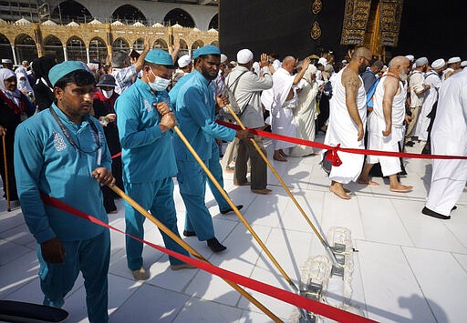 Workers sterilize the ground in front of the Kaaba, the cubic building at the Grand Mosque, in the Muslim holy city of Mecca, Saudi Arabia, Thursday, March 5, 2020. Saudi Arabia's Deputy Health Minister Abdel-Fattah Mashat was quoted on the state-linked news site Al-Yaum saying that groups of visitors to Mecca from inside the country would now also be barred from performing the pilgrimage, known as the umrah. (AP Photo/Amr Nabil)