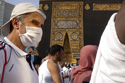 A relatively few number of Muslims pray around the Kaaba, the cubic building at the Grand Mosque, in the Muslim holy city of Mecca, Saudi Arabia, Thursday, March 5, 2020. Saudi Arabia's Deputy Health Minister Abdel-Fattah Mashat was quoted on the state-linked news site Al-Yaum saying that groups of visitors to Mecca from inside the country would now also be barred from performing the pilgrimage, known as the umrah. (AP Photo/Amr Nabil)