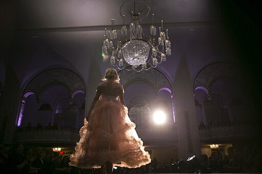 Asher, 12, walks down the catwalk in her peach-colored gown during a fashion show on Friday, Jan. 31, 2020, in Boston. Asher identifies as non-binary and preferred pronoun is just &quot;Asher.&quot; Teachers, staff and students in Asher's school have come to understand: Asher is not a boy, not a girl. Asher is non-binary. Asher is Asher. (AP Photo/Wong Maye-E)