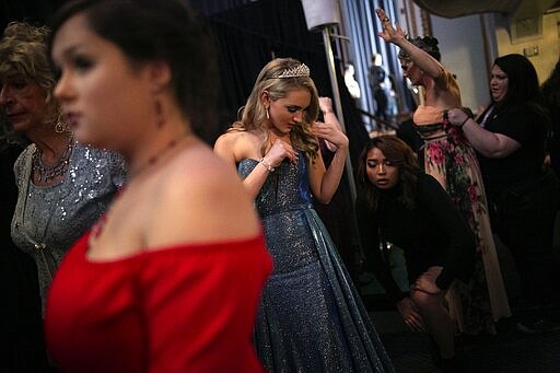 Emily Tressa, 18, center, looks down while her best friend AJ adjusts her gown ahead of a fashion show on Friday, Jan. 31, 2020, in Boston. Emily has lived as a girl since fourth grade. With gender reassignment surgery last June, her transformation became complete. (AP Photo/Wong Maye-E)