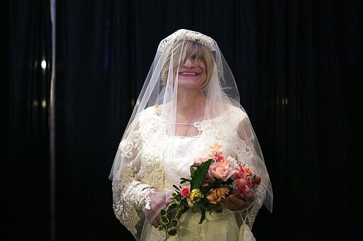 Samantha Ambrose smiles for a photograph dressed in a wedding gown which she modeled as one of three outfits she wore at the TransFORMED fashion show on Friday, Jan. 31, 2020, in Boston. (AP Photo/Wong Maye-E)