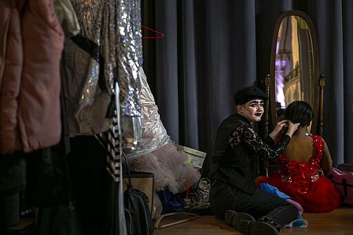 Lancelin Si'l-Vous-Plait, 16, left, helps to braid the hair of their sister, Valerie Suero, 9, in preparation for a fashion show on Friday, Jan. 31, 2020, in Boston. The presentation is part of the First Event Conference, held for four decades by the Trans Club of New England. (AP Photo/Wong Maye-E)