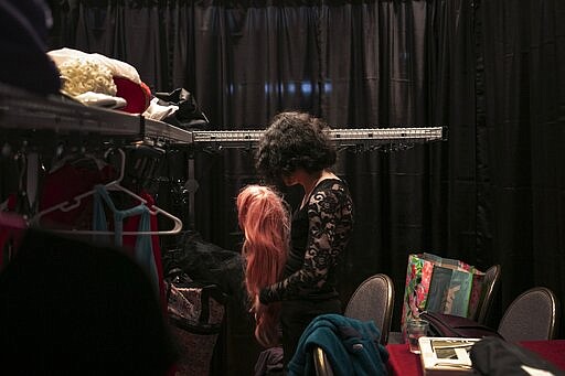 Sarah Langer, 25, prepares a wig for her next outfit in the TransFORMED fashion show on Friday, Jan. 31, 2020, in Boston. Sarah says she loves art, fashion and music. She plays guitar semi-professionally and has been playing gigs while back home in New York City. (AP Photo/Wong Maye-E)