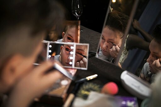 Leon Dell'era, 15, draws on eyeliner backstage during a fashion show where he will present three different outfits on Friday, Jan. 31, 2020, in Boston. For many years, the TransFORMED fashion show featured male-to-female crossdressers. But over time, the focus has become less about the clothes, and more about the people in them. (AP Photo/Wong Maye-E)